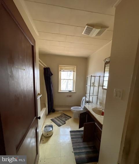 bathroom featuring toilet, tile patterned floors, visible vents, vanity, and shower / tub combo with curtain