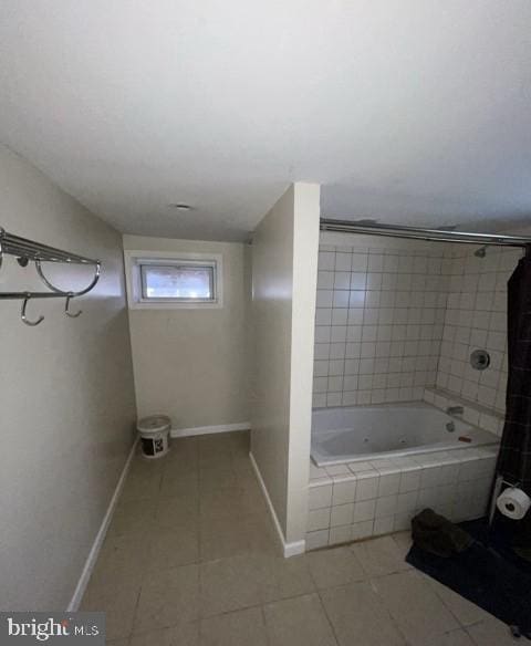 bathroom featuring tiled tub, baseboards, a tile shower, and tile patterned floors