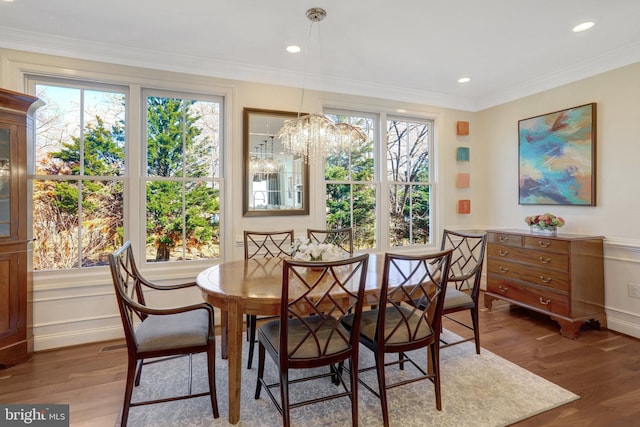 dining area with crown molding, wood finished floors, and a wealth of natural light