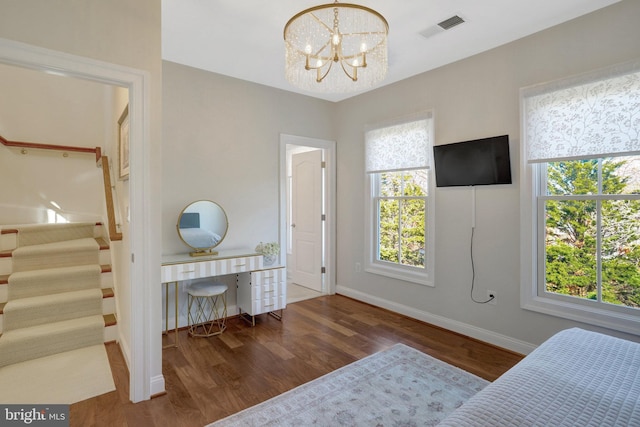 bedroom with visible vents, baseboards, an inviting chandelier, and wood finished floors