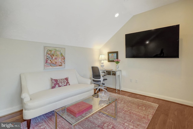 living room featuring vaulted ceiling, wood finished floors, and baseboards