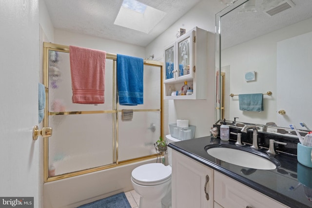 bathroom with a textured ceiling, toilet, a skylight, vanity, and visible vents