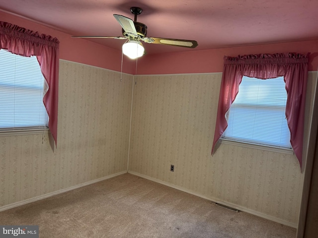 carpeted spare room with a wealth of natural light, baseboards, and wallpapered walls