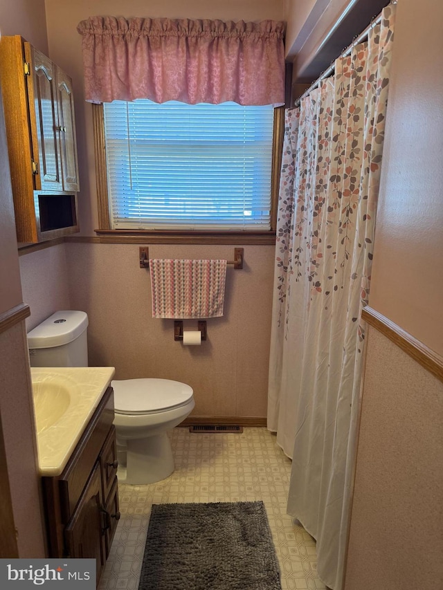 bathroom featuring toilet, vanity, visible vents, and tile patterned floors