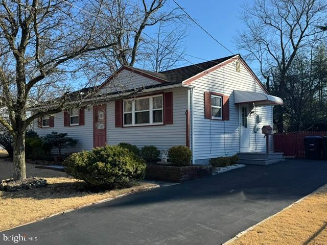 view of property exterior featuring driveway and fence