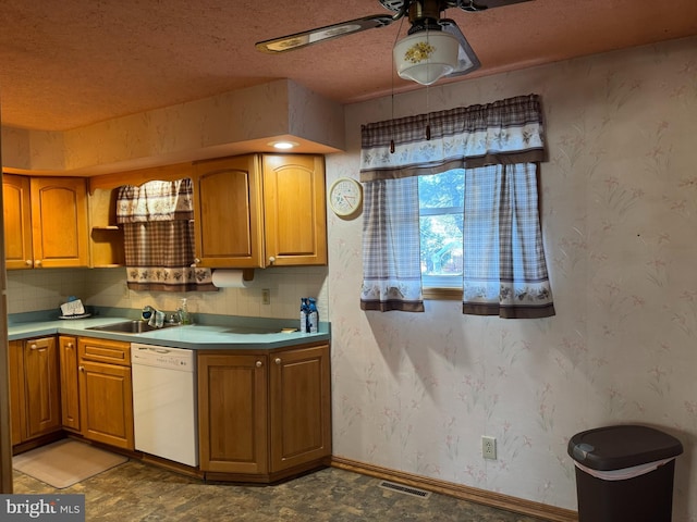 kitchen with white dishwasher, a sink, and wallpapered walls