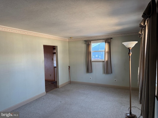 carpeted spare room with a textured ceiling and baseboards