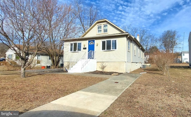 bungalow featuring cooling unit and a chimney