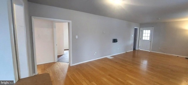 empty room with light wood-type flooring and baseboards