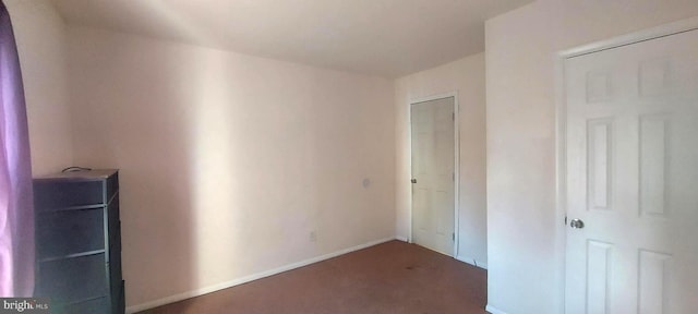 unfurnished bedroom with a closet, carpet flooring, and baseboards