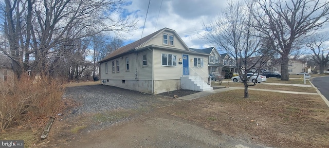 view of side of property featuring driveway and entry steps