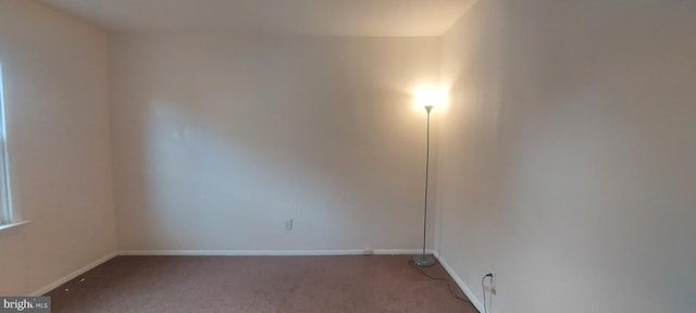 spare room with carpet and baseboards