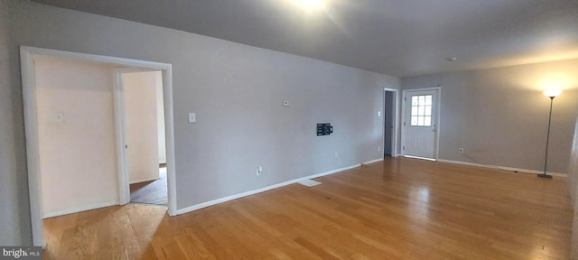 unfurnished room featuring baseboards and wood finished floors