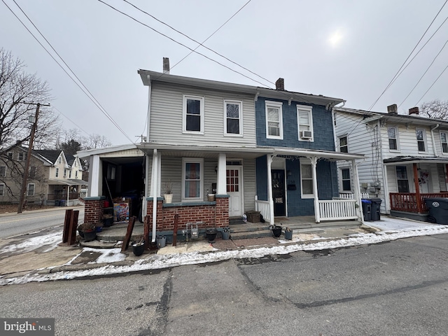 view of front of home featuring covered porch and a chimney