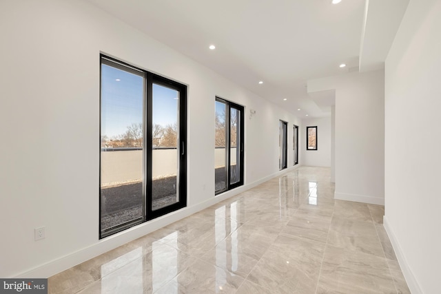 spare room featuring recessed lighting, baseboards, and marble finish floor