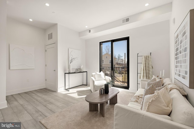 living area featuring recessed lighting, visible vents, baseboards, and light wood finished floors