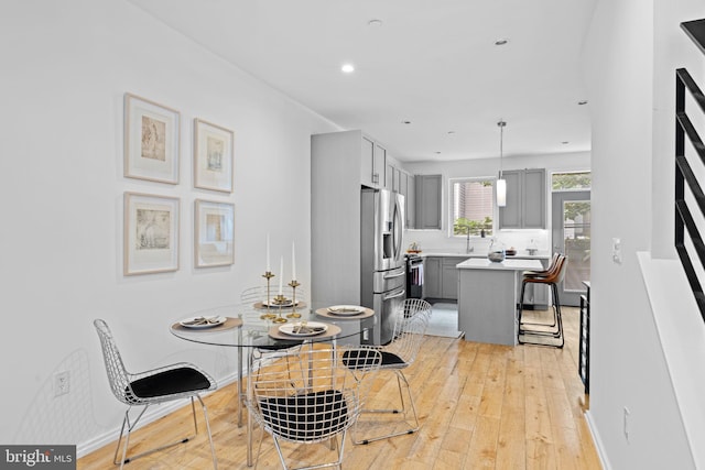 dining space with recessed lighting, light wood-style flooring, and baseboards