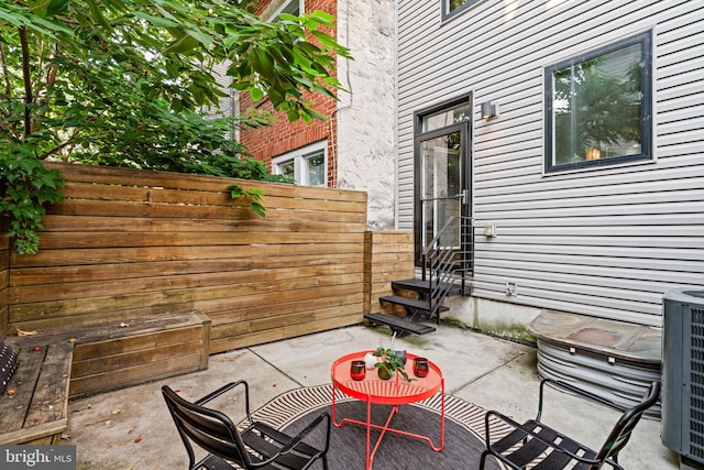 view of patio / terrace featuring fence and central AC unit