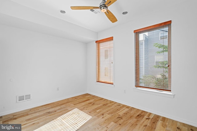 unfurnished room with baseboards, visible vents, ceiling fan, and wood finished floors