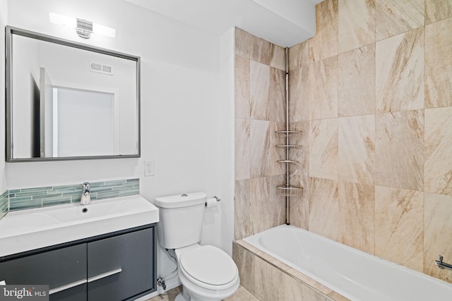 bathroom with visible vents, decorative backsplash, toilet, tiled shower / bath combo, and vanity