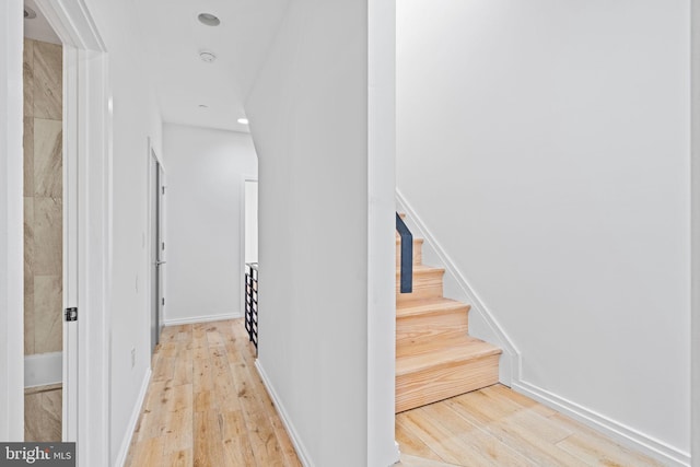 staircase featuring baseboards, hardwood / wood-style flooring, and recessed lighting