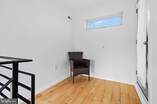 sitting room featuring baseboards, visible vents, and hardwood / wood-style floors