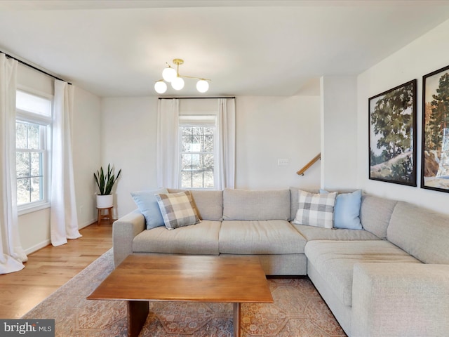 living area with baseboards, plenty of natural light, and light wood finished floors