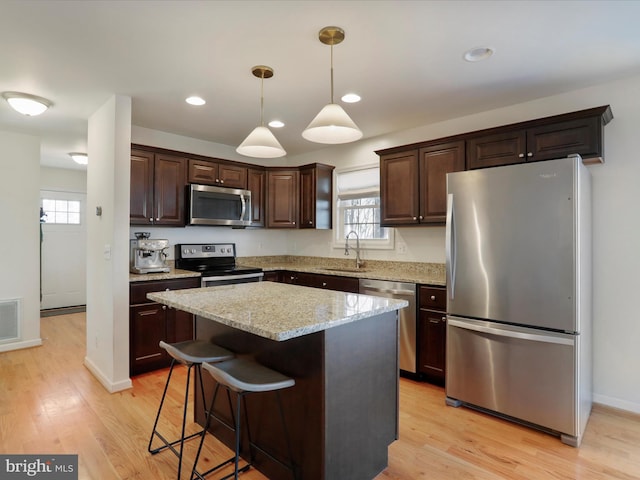 kitchen featuring a sink, light wood-type flooring, appliances with stainless steel finishes, and dark brown cabinets