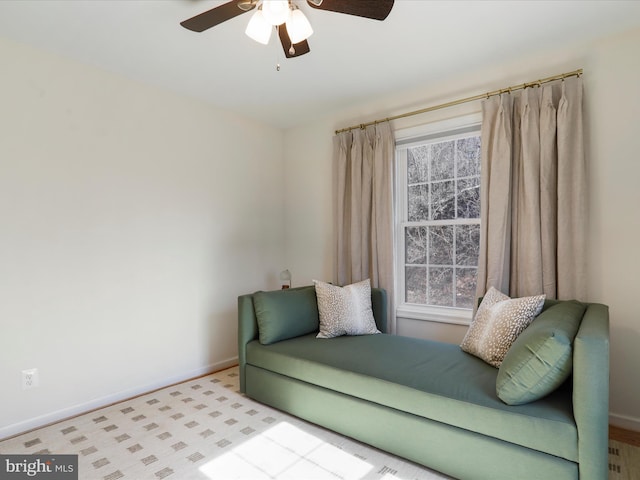 sitting room with a ceiling fan and baseboards