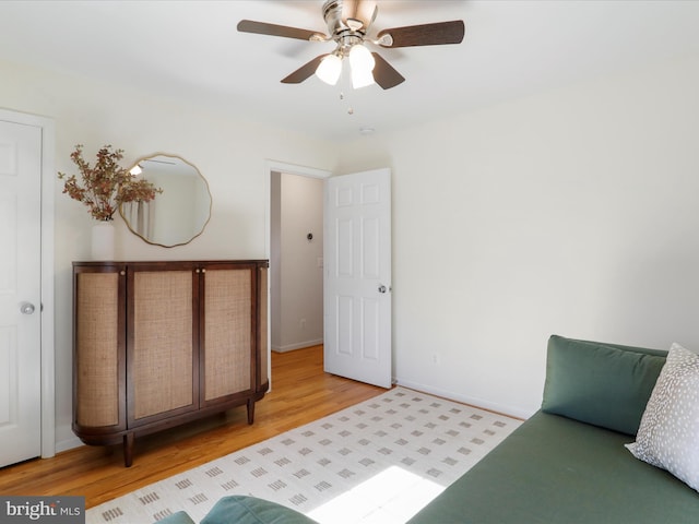 bedroom with a ceiling fan, baseboards, and light wood-type flooring