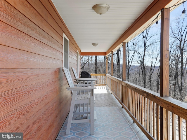 exterior space featuring covered porch and a wooded view