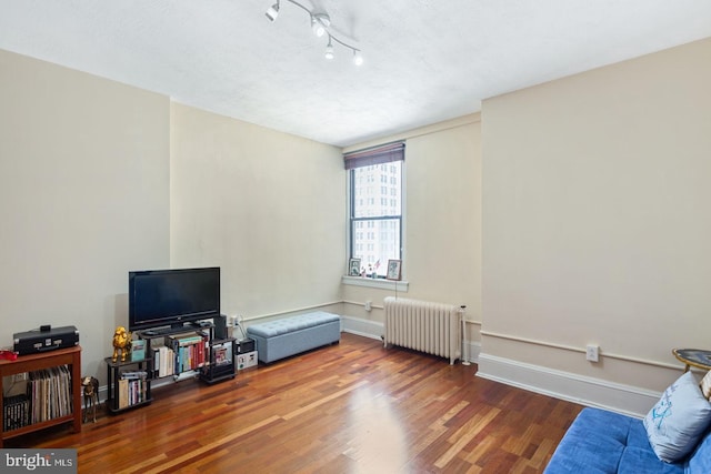 interior space with radiator, baseboards, and wood finished floors