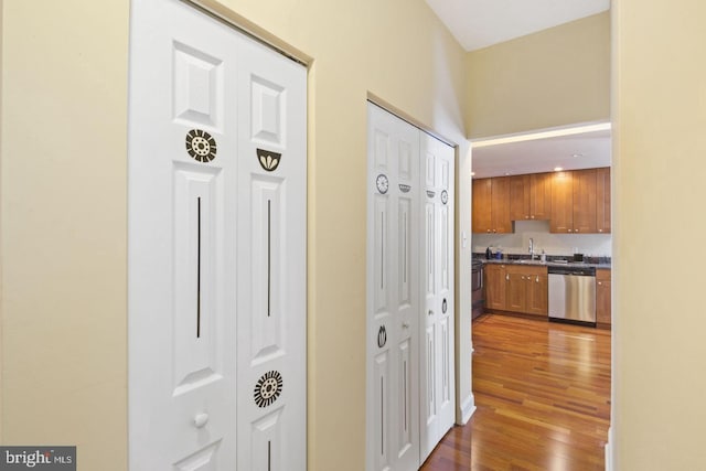 hall with a sink and wood finished floors