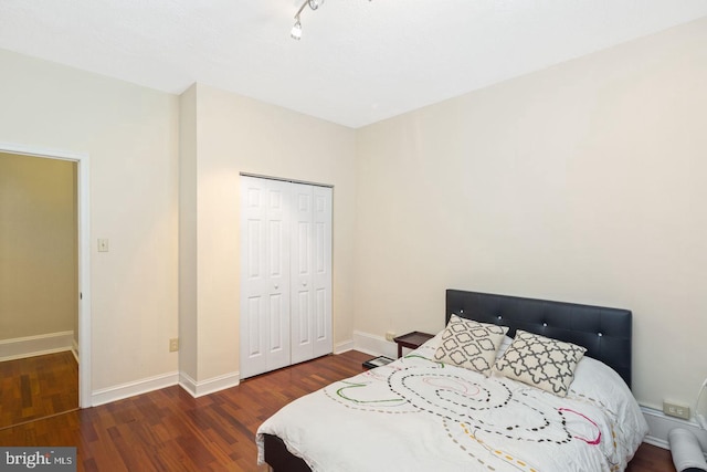 bedroom featuring a closet, baseboards, and wood finished floors