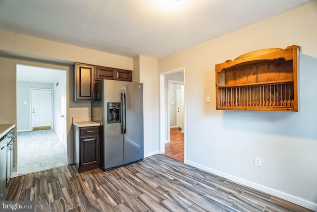 kitchen featuring baseboards, light countertops, dark wood-style flooring, and stainless steel fridge with ice dispenser