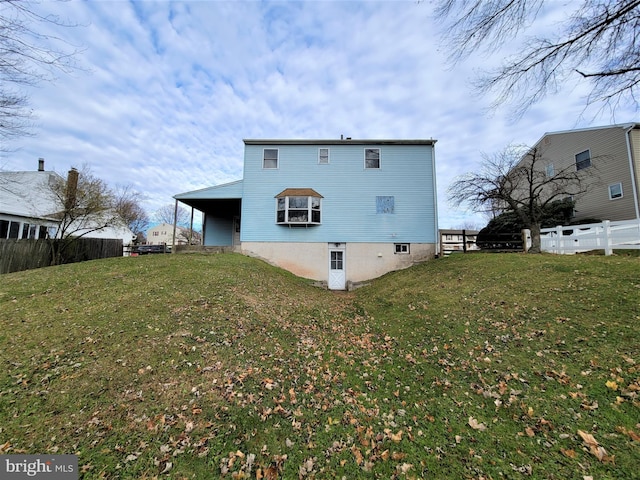 rear view of house with a yard and fence