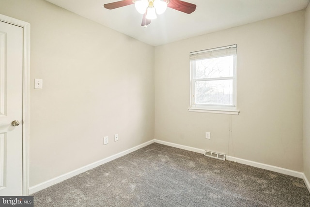 carpeted spare room with baseboards, visible vents, and ceiling fan