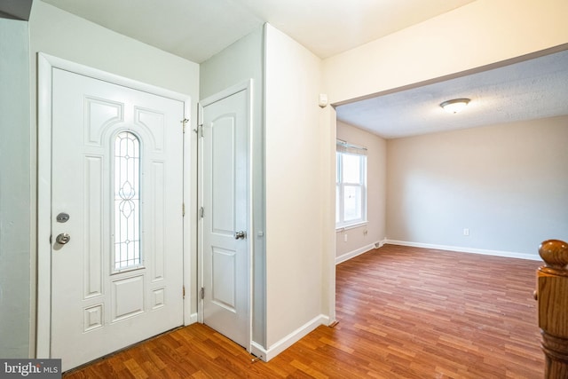 entrance foyer with baseboards and wood finished floors