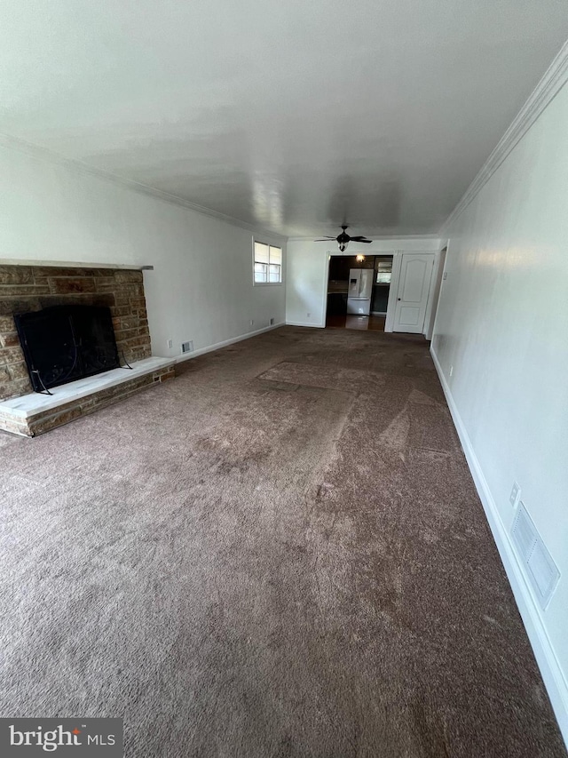 8211 Beach Dr, Baltimore, MD 21222 - unfurnished living room featuring ornamental molding, a fireplace with raised hearth, carpet, a ceiling fan, and baseboards