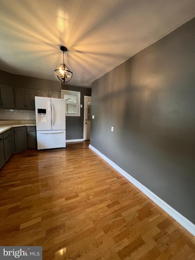 8211 Beach Dr, Baltimore, MD 21222 - unfurnished dining area with light wood finished floors, a chandelier, and baseboards