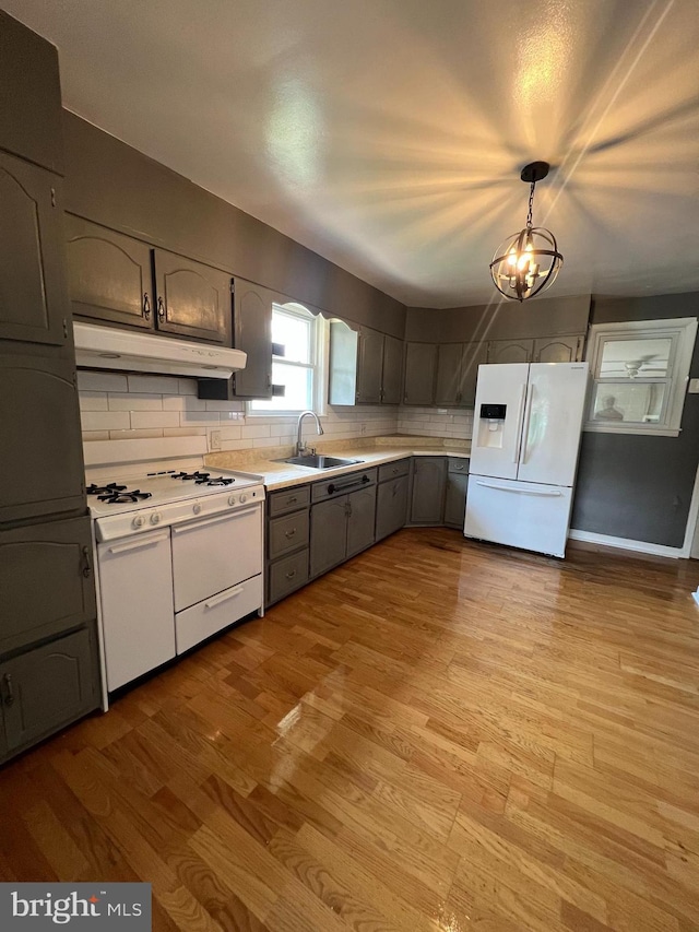 8211 Beach Dr, Baltimore, MD 21222 - kitchen with white appliances, under cabinet range hood, a sink, tasteful backsplash, and light countertops