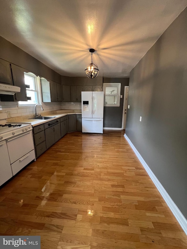 8211 Beach Dr, Baltimore, MD 21222 - kitchen with white appliances, a sink, a chandelier, light countertops, and light wood-style floors