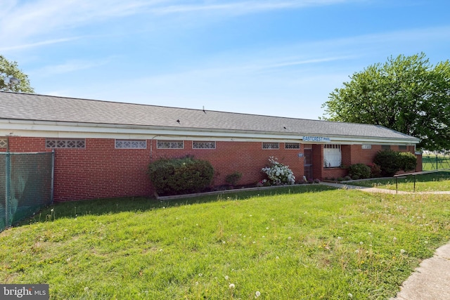 exterior space featuring a lawn, fence, and brick siding