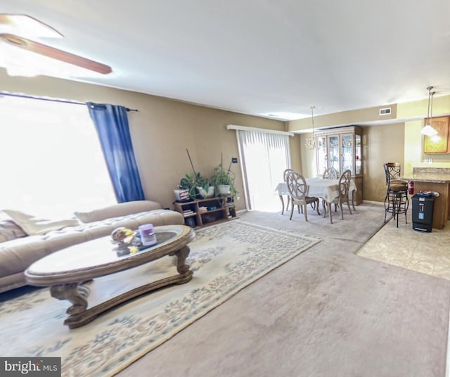 living area with visible vents and ceiling fan