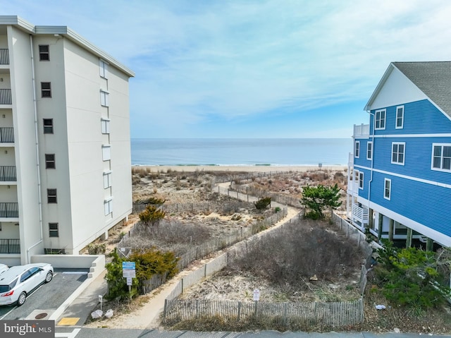 property view of water with a beach view and fence