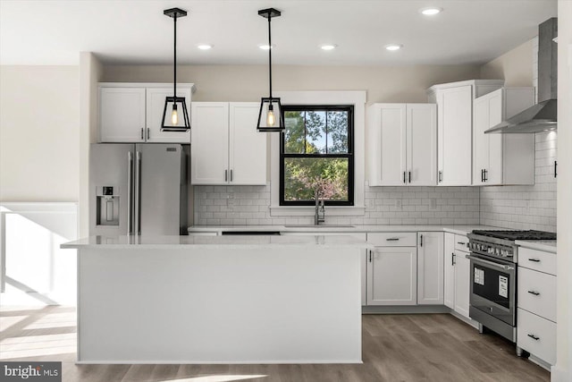 kitchen featuring wall chimney range hood, stainless steel appliances, a sink, and light countertops