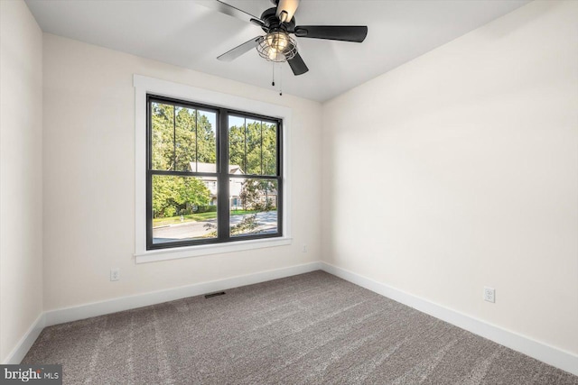 carpeted empty room featuring a ceiling fan and baseboards