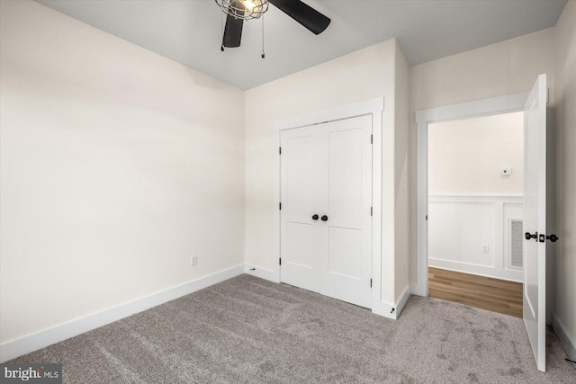 unfurnished bedroom with a closet, carpet flooring, a ceiling fan, and baseboards