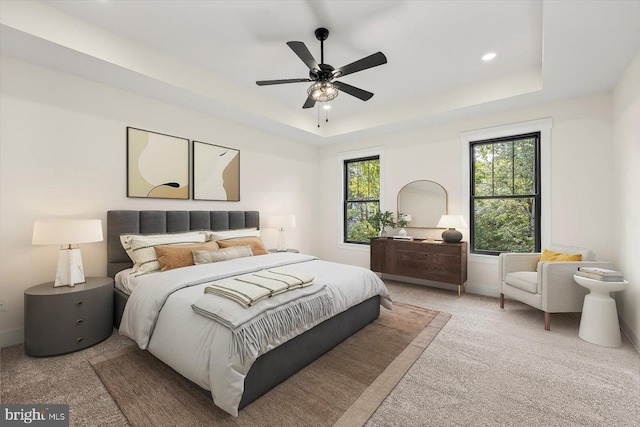 carpeted bedroom with a ceiling fan, recessed lighting, and a raised ceiling