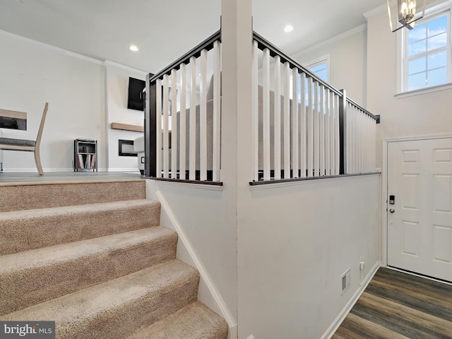 stairway featuring recessed lighting, baseboards, crown molding, and wood finished floors